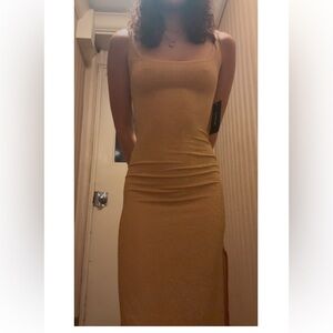 gold bodycon dress with slit starting at fingertips